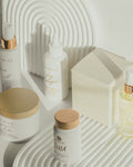 Skincare products with gold and white packaging on a neutral background